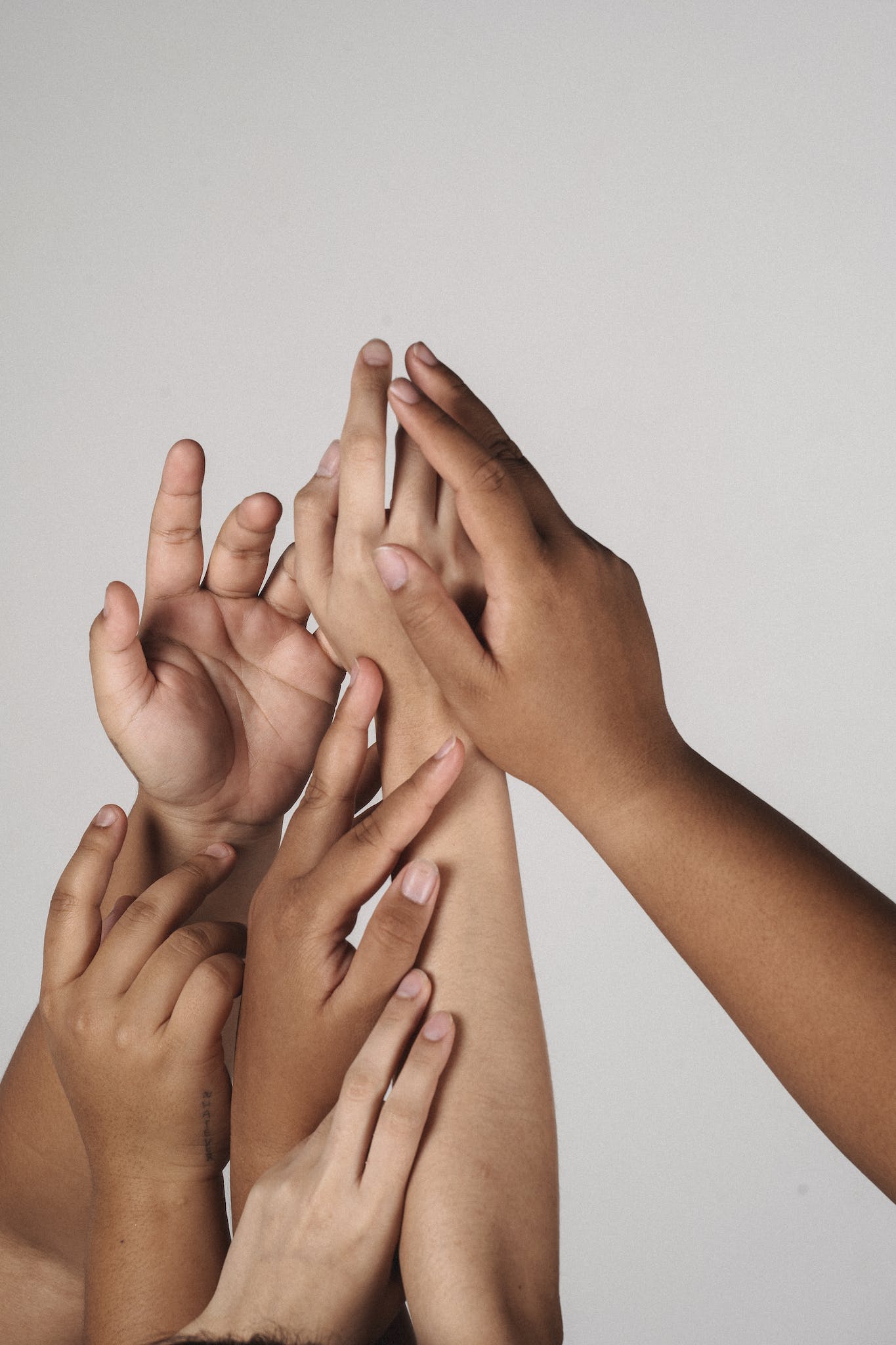 Crop multiracial unrecognizable female joining hands together supporting each other and accepting individuality of each other